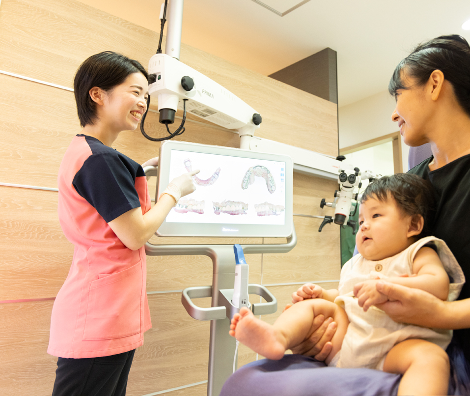 子供を抱えた母親に説明するスタッフ